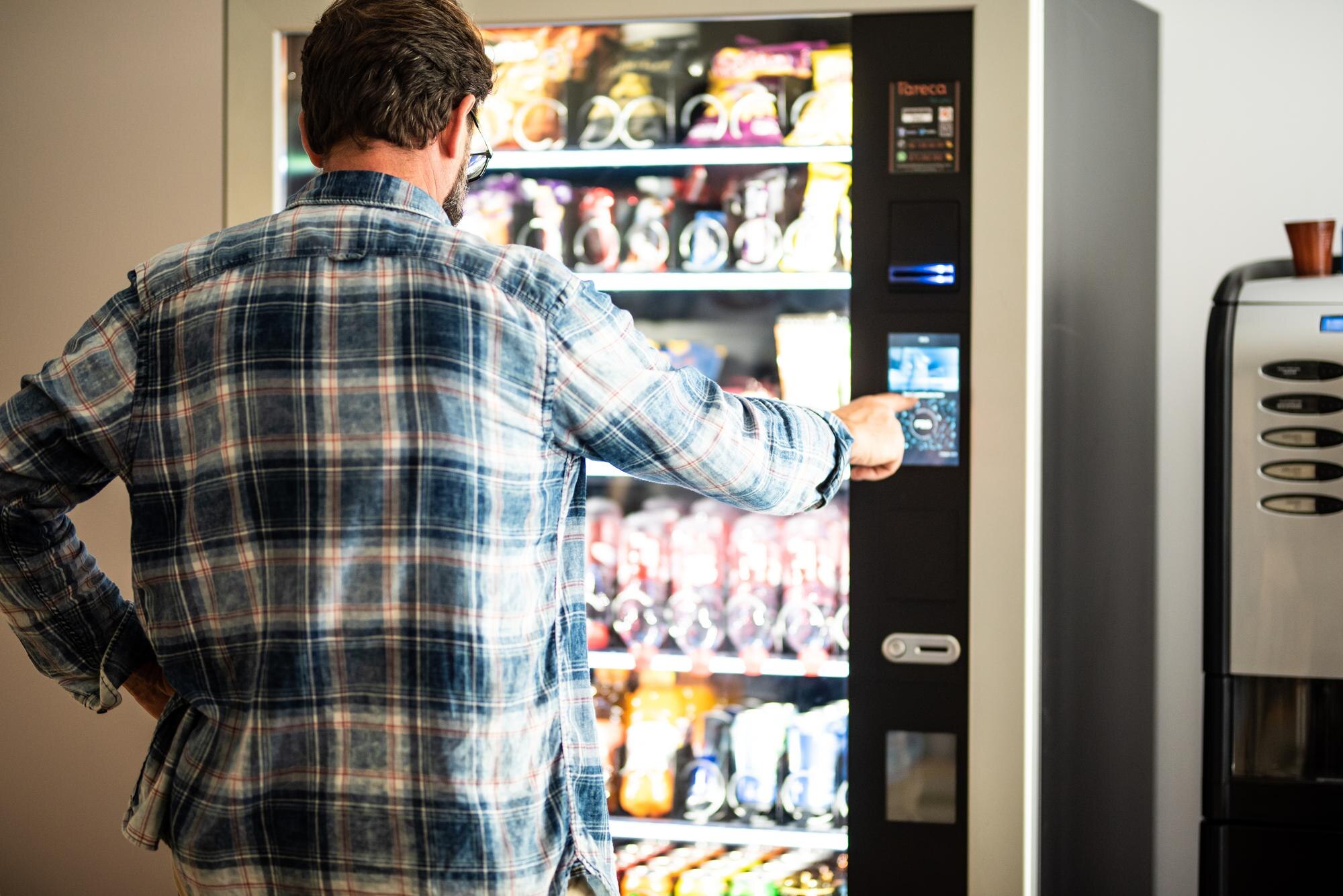 rear view man using vending machine